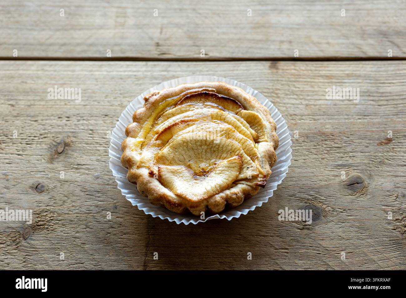 Mini tarte aux pommes avec des tranches de pommes caramélisées éparpillées Banque D'Images