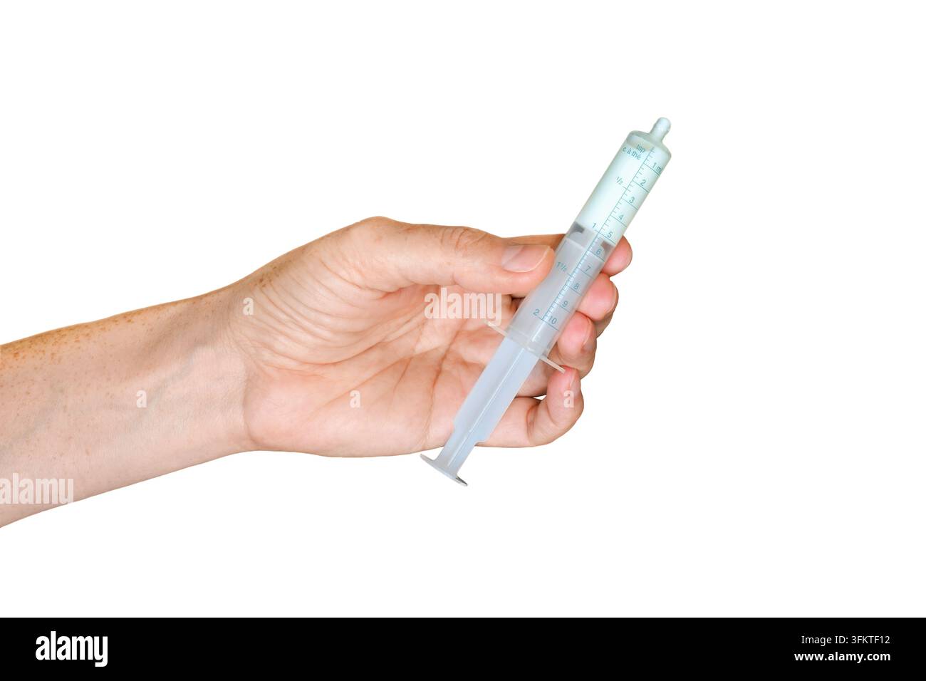 Vue latérale d'une main tenant une seringue orale en plastique transparent remplie d'un liquide médical blanc, isolée sur un fond blanc Banque D'Images