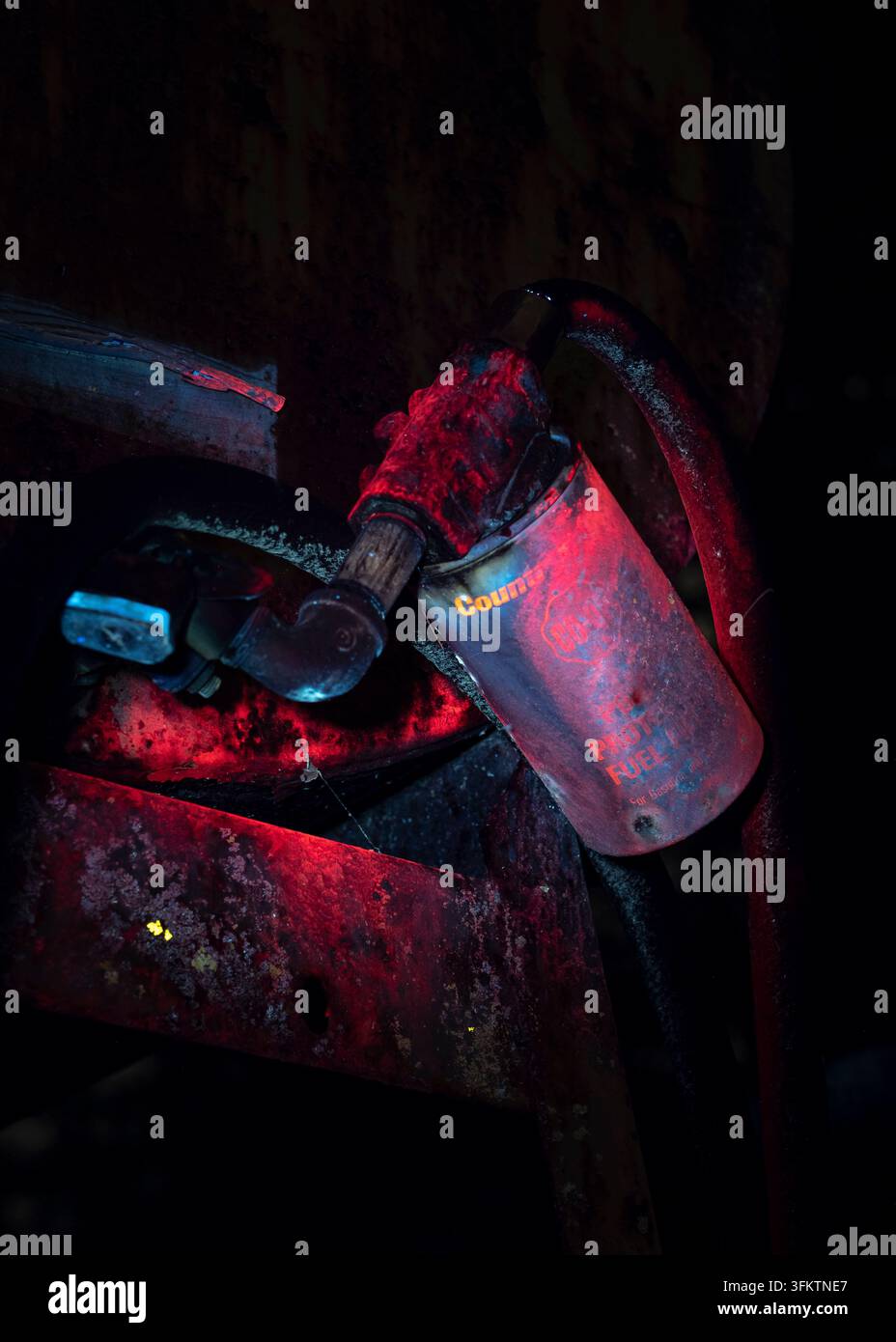 Une vieille pompe à essence en métal la nuit, éclairée par une lampe UV Banque D'Images