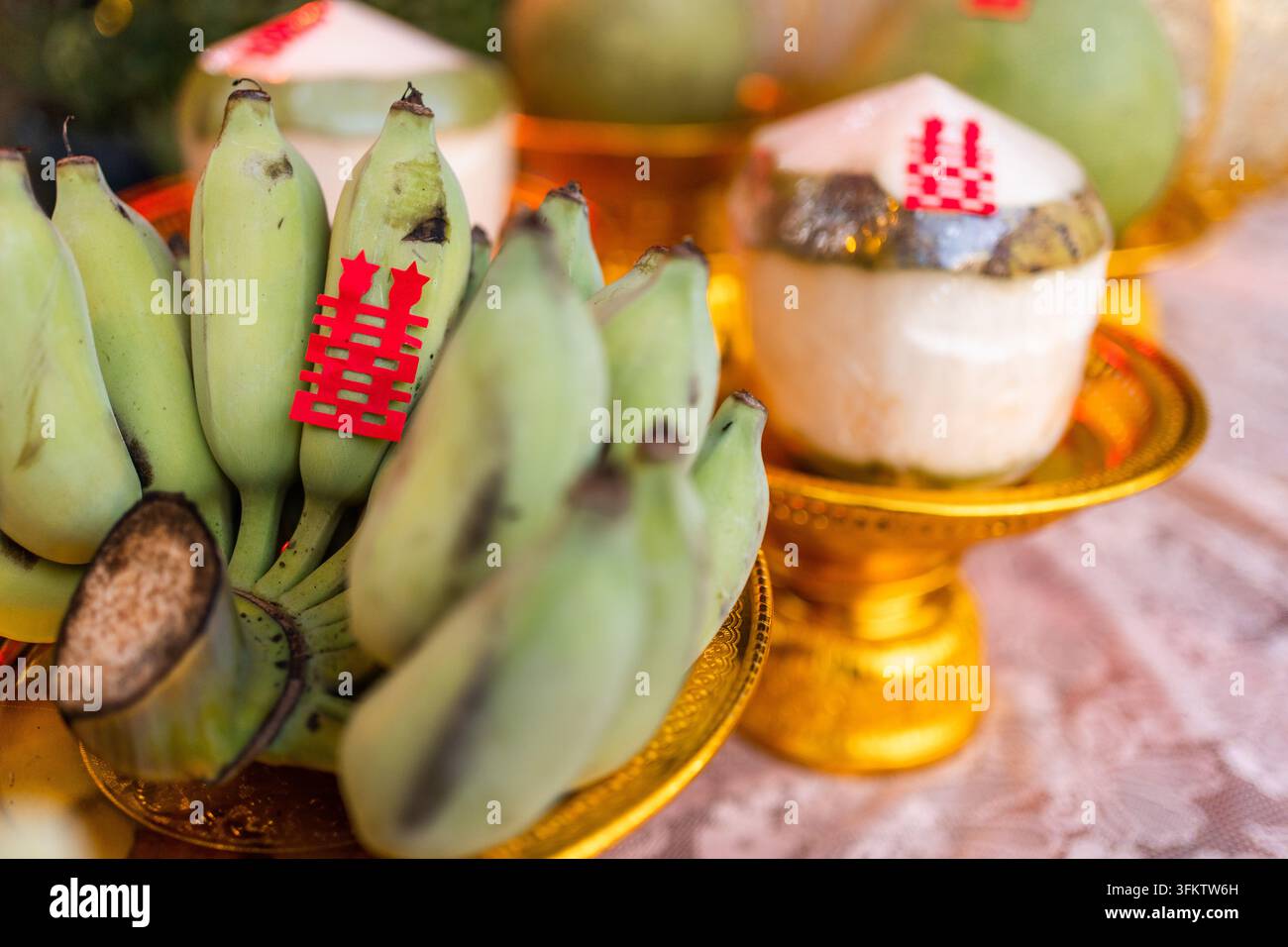 Objets de bon augure traditionnels pour un mariage avec des bananes vertes et des noix de coco sur des plateaux dorés Banque D'Images
