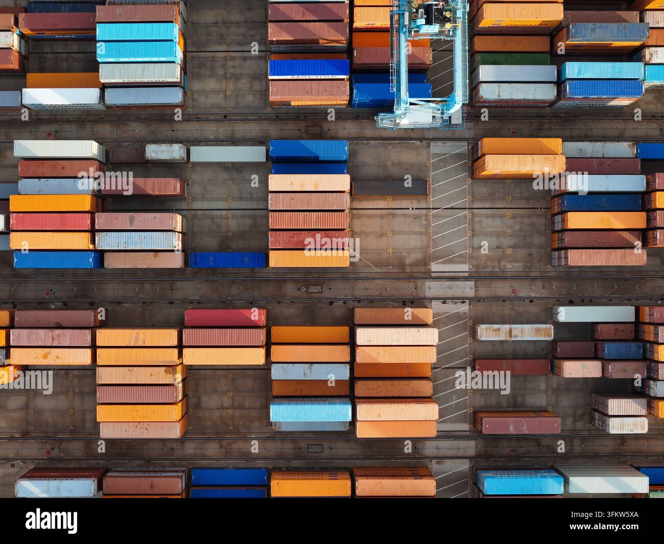 Vue aérienne du port de conteneurs semi-automatisé présentant des rangées de conteneurs de transport colorés et une infrastructure de stockage automatisée à Vado Ligu Banque D'Images