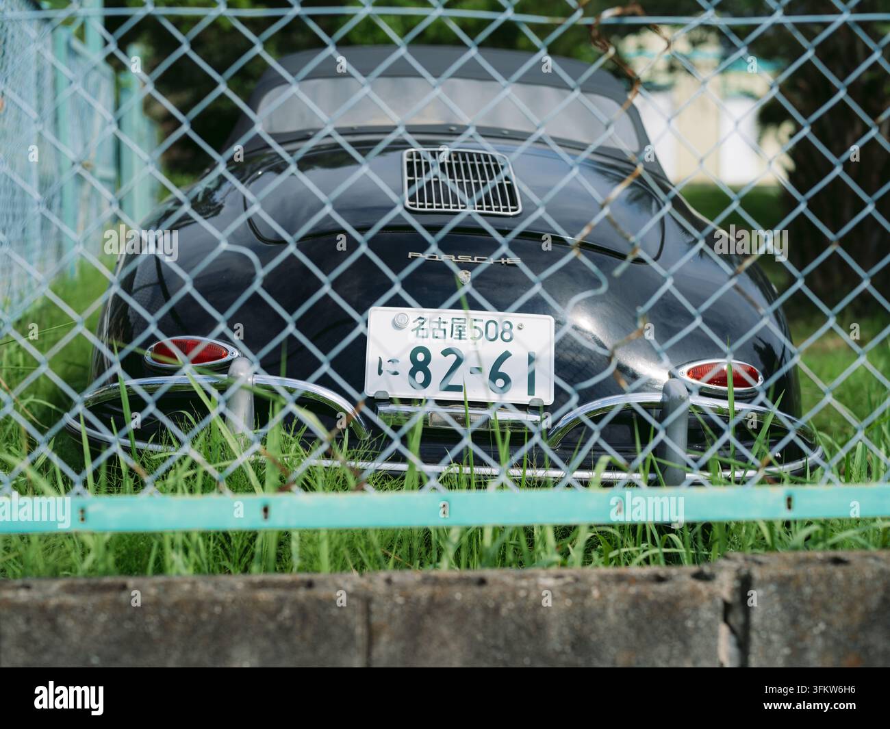 Porsche 356 noir classique garé sur l'herbe côtière avec des palmiers à Aichi, Japon Banque D'Images