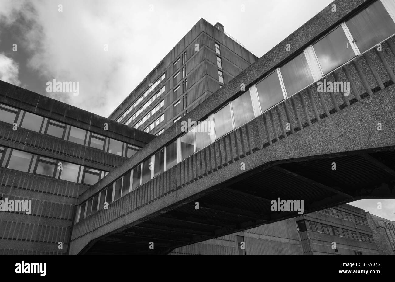 Vue en contre-plongée d'une passerelle en béton brutaliste reliant des bâtiments de bureaux modernistes Banque D'Images