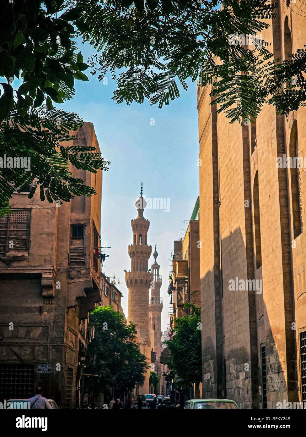 Vue le long de la rue Bab Al-Wazir vers la Mosquée Bleue (Mosquée Aqsunqur) encadrée par des bâtiments historiques dans le Caire islamique, Égypte. - Image de stock capturée avec un smartphone