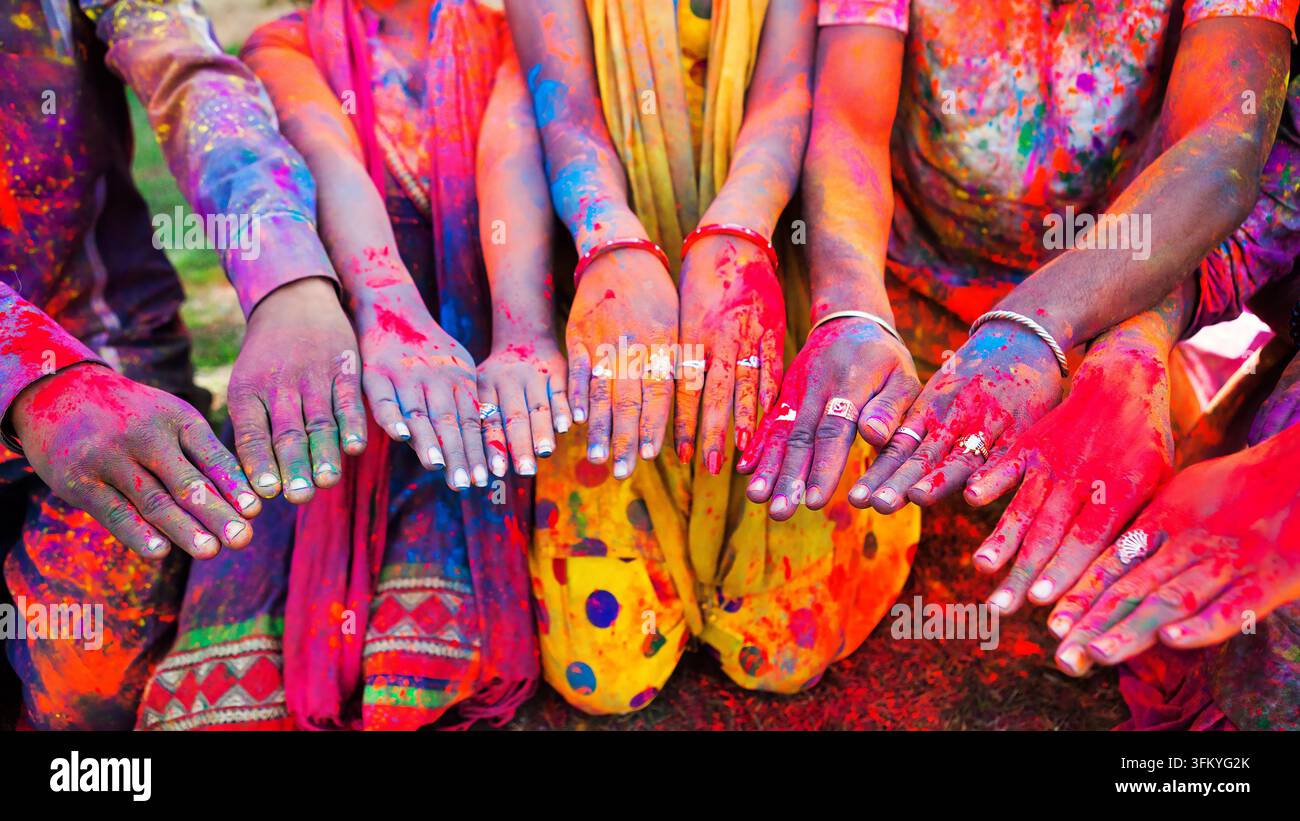 Mains couvertes de poudre colorée tendues ensemble pendant le festival du printemps hindou Holi à Jaipur, Rajasthan, Inde. Banque D'Images