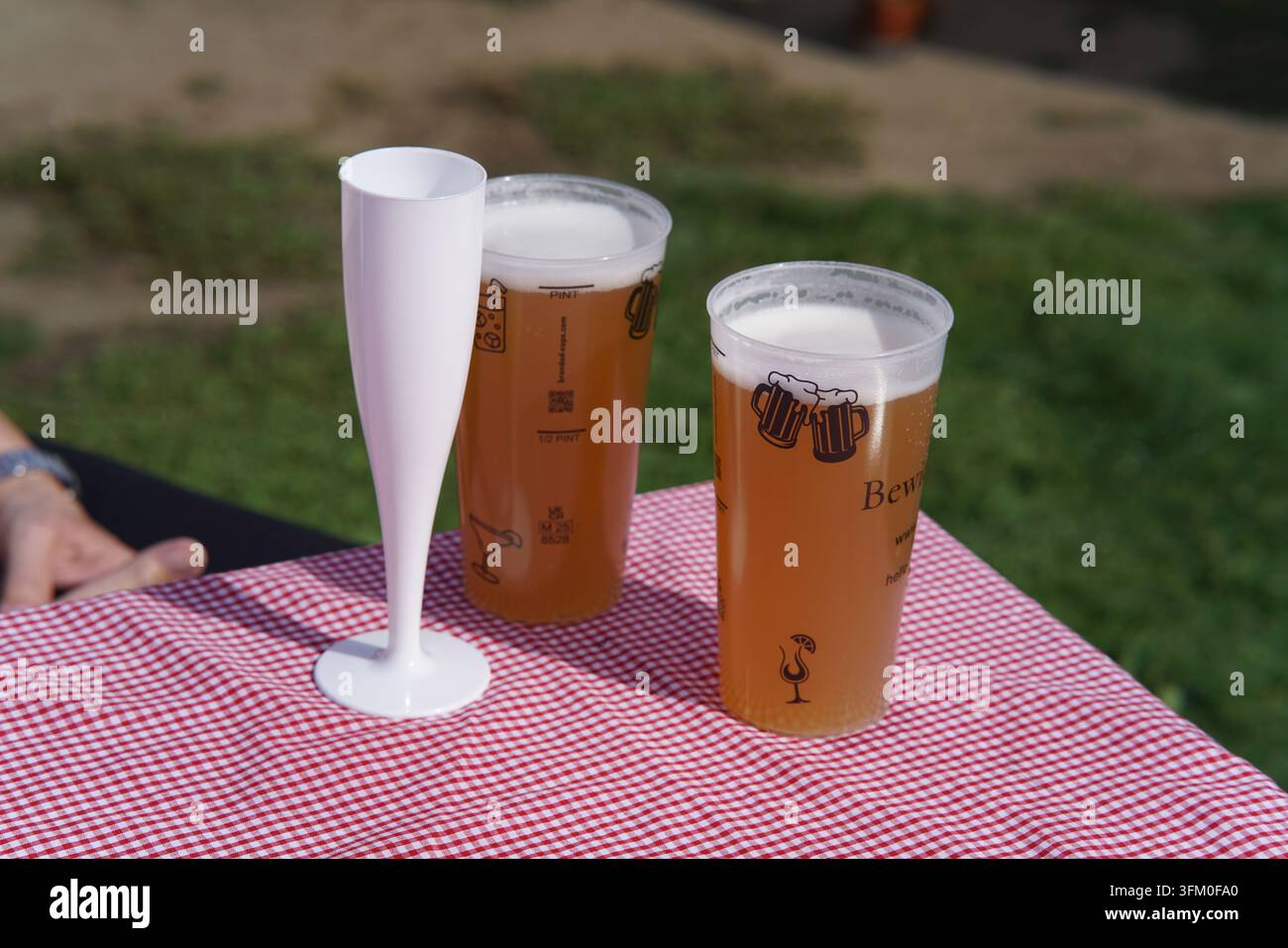 Deux pintes de bière et une flûte vide sur une table à carreaux au Food Festival de Royal Tunbridge Wells, en Angleterre. Banque D'Images