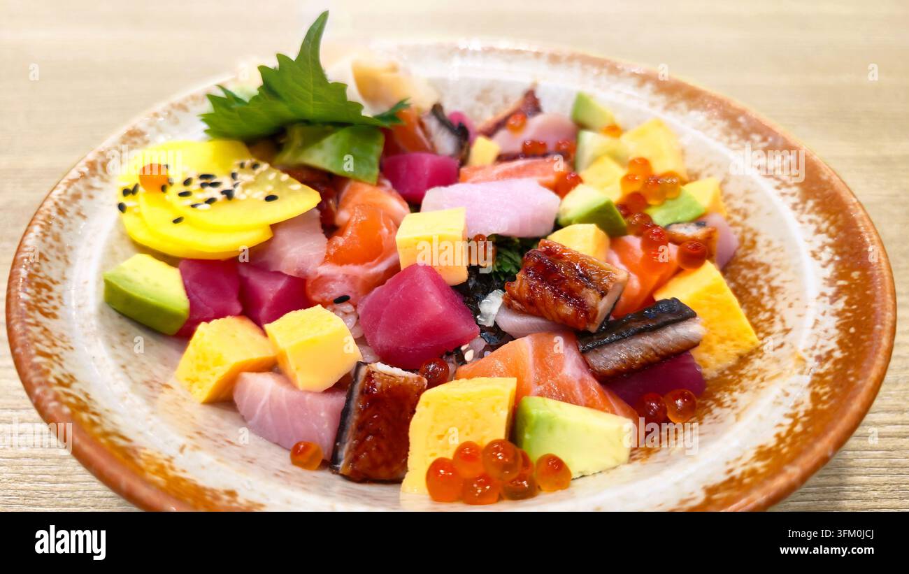 Bol de sushi chirashi japonais coloré avec saumon, thon, anguille, avocat, tamago, œufs de saumon et sashimi frais assortis servis sur du riz à sushi. - Image de stock capturée avec un smartphone