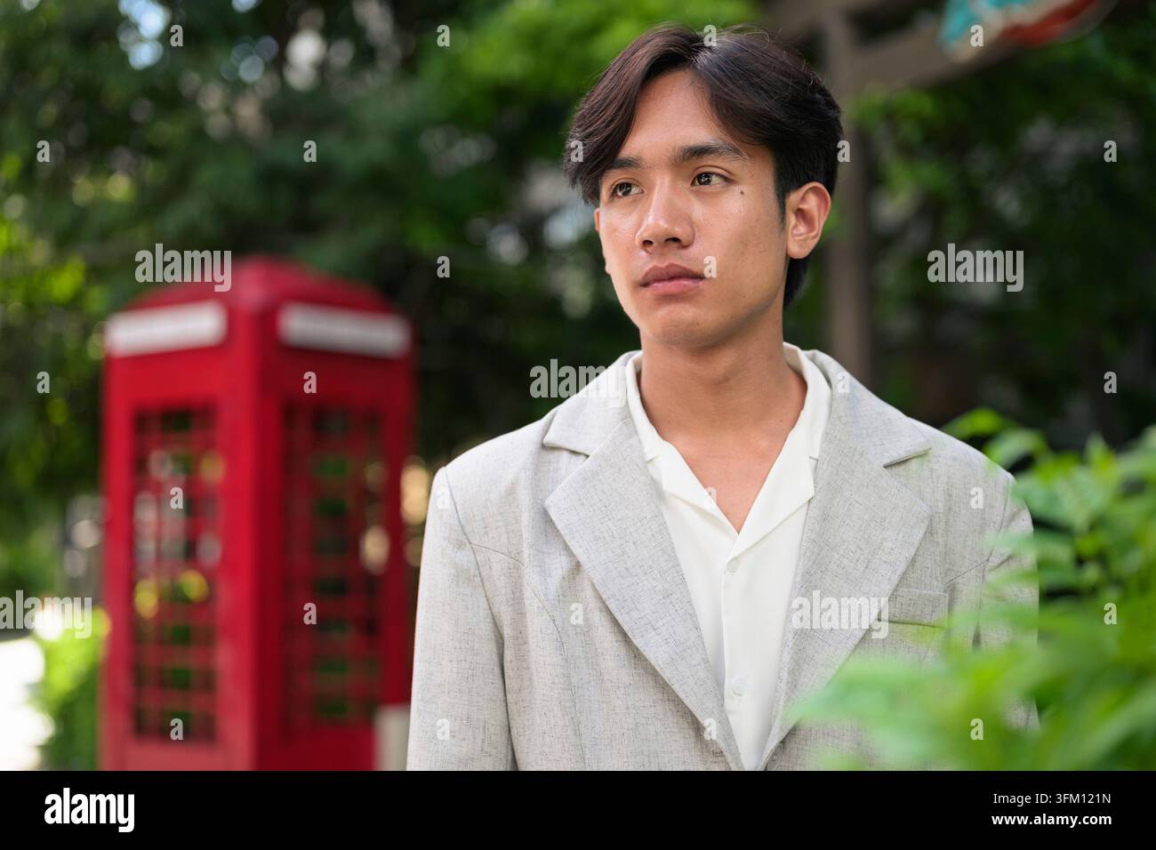 Portrait de style de vie horizontal authentique d'un jeune professionnel thaïlandais Isan non binaire ou étudiant regardant loin avec une expression sérieuse. Dépassement de soi Banque D'Images