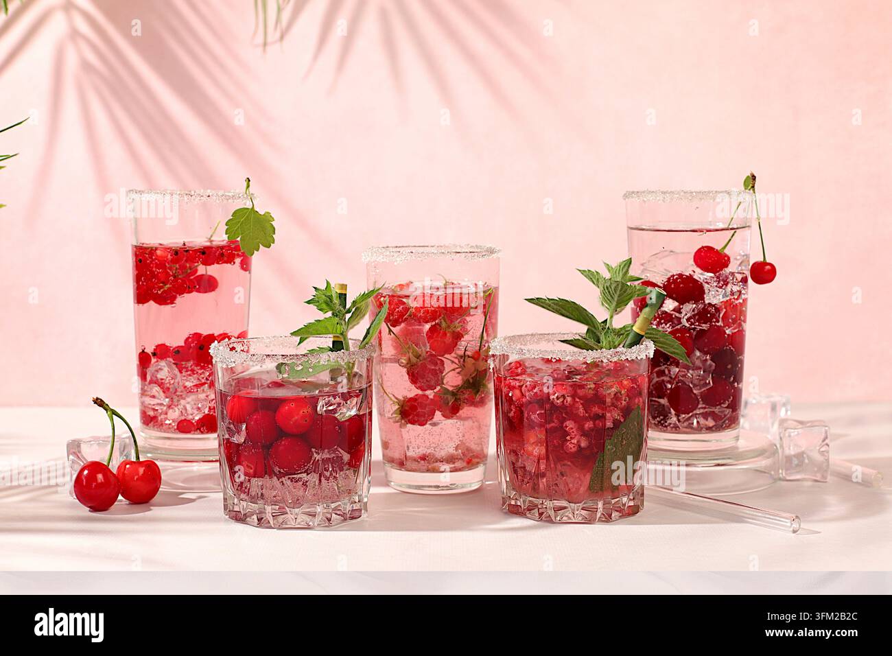 Eau détox avec framboises, cerises et groseilles sur glace. Un cocktail de limonade maison rafraîchissant d'été. Jus de fruits et ingrédients, perte de poids Banque D'Images