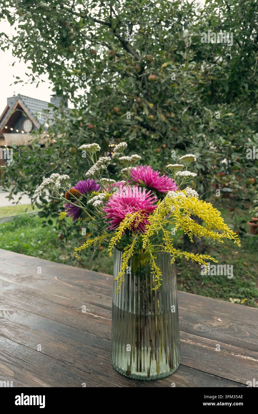 Bouquet de fleurs sauvages coloré d'automne dans un vase en verre cannelé en plein air - Image de stock capturée avec un smartphone