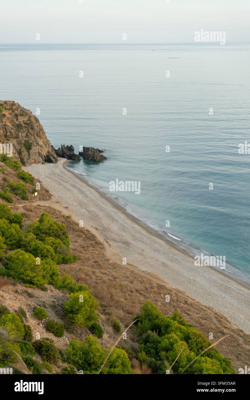Cette vue à couper le souffle capture une crique isolée nichée le long d'une côte déchiquetée, mettant en valeur la beauté tranquille de la mer Méditerranée. La scène Banque D'Images