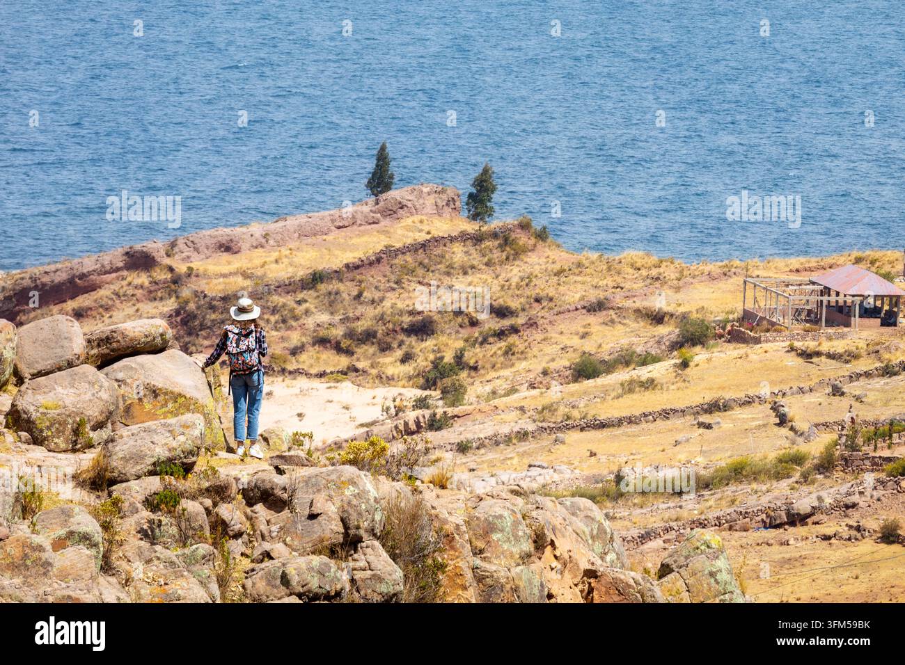 Touriste explorant le paysage rocheux surplombant le lac Titicaca, Pérou Banque D'Images