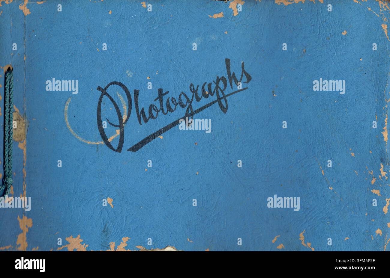 Album photo vintage du milieu du siècle avec une couverture en carton bleu vif texturé et une inscription en écriture cursive noire lisant „Photographs macro scan" Banque D'Images