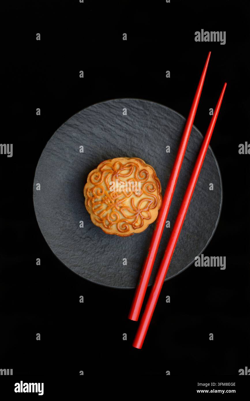 Mooncake, mooncake sur une assiette avec des baguettes, Chine Banque D'Images