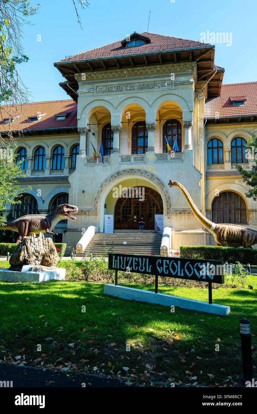 Façade du Musée géologique national à Bucarest, Roumanie, présentant des modèles de dinosaures en plein air et une architecture néo-roumaine traditionnelle. Banque D'Images