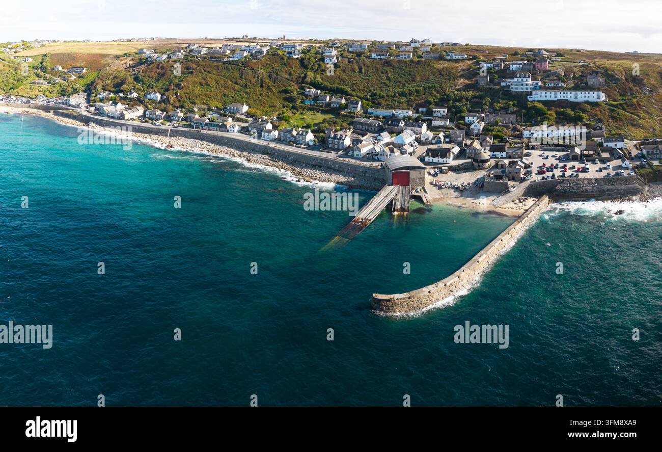 Vue aérienne depuis la mer du village et de la plage de Sennen Cove dans les Cornouailles, au Royaume-Uni, une destination de vacances d'été populaire pour les vacanciers Banque D'Images