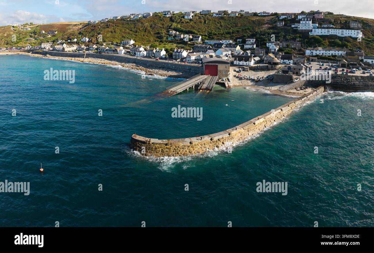 Vue aérienne depuis la mer du village et de la plage de Sennen Cove dans les Cornouailles, au Royaume-Uni, une destination de vacances d'été populaire pour les vacanciers Banque D'Images