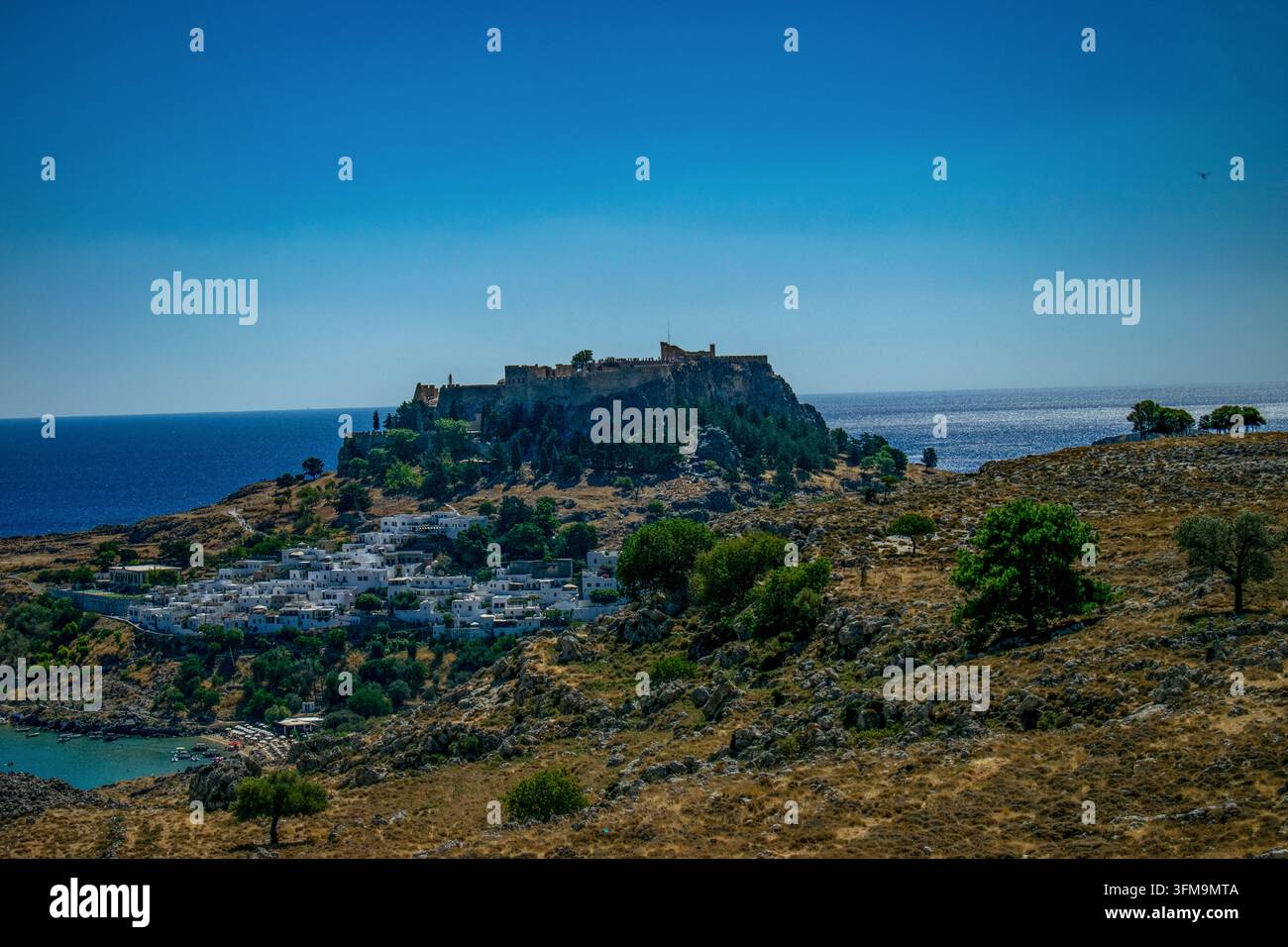 Le village de Lindos et son acropole historique sur la colline surplombant la mer Égée à Rhodes, en Grèce. Banque D'Images