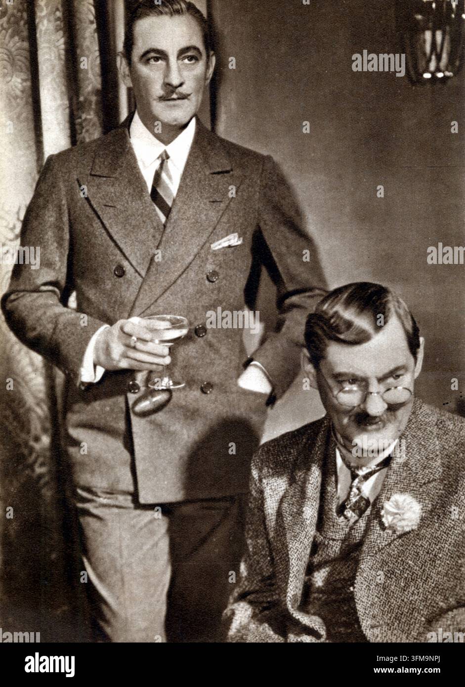 Une photographie représentant John Barrymore (1882–1942) et Lionel Barrymore (1878–1954). Les frères, membres de la renommée dynastie théâtrale Barrymore, sont apparus ensemble dans le film Metro-Goldwyn-Mayer Dinner at Eight. John Barrymore, célèbre sous le nom de « The Great Profile », incarnait l’idole déchue Larry Renault, tandis que Lionel Barrymore jouait le magnat des transports maritimes Oliver Jordan. Ils étaient les frères de l’actrice Ethel Barrymore et des figures éminentes de la scène et de l’écran américains au début du XXe siècle. 1933. Banque D'Images