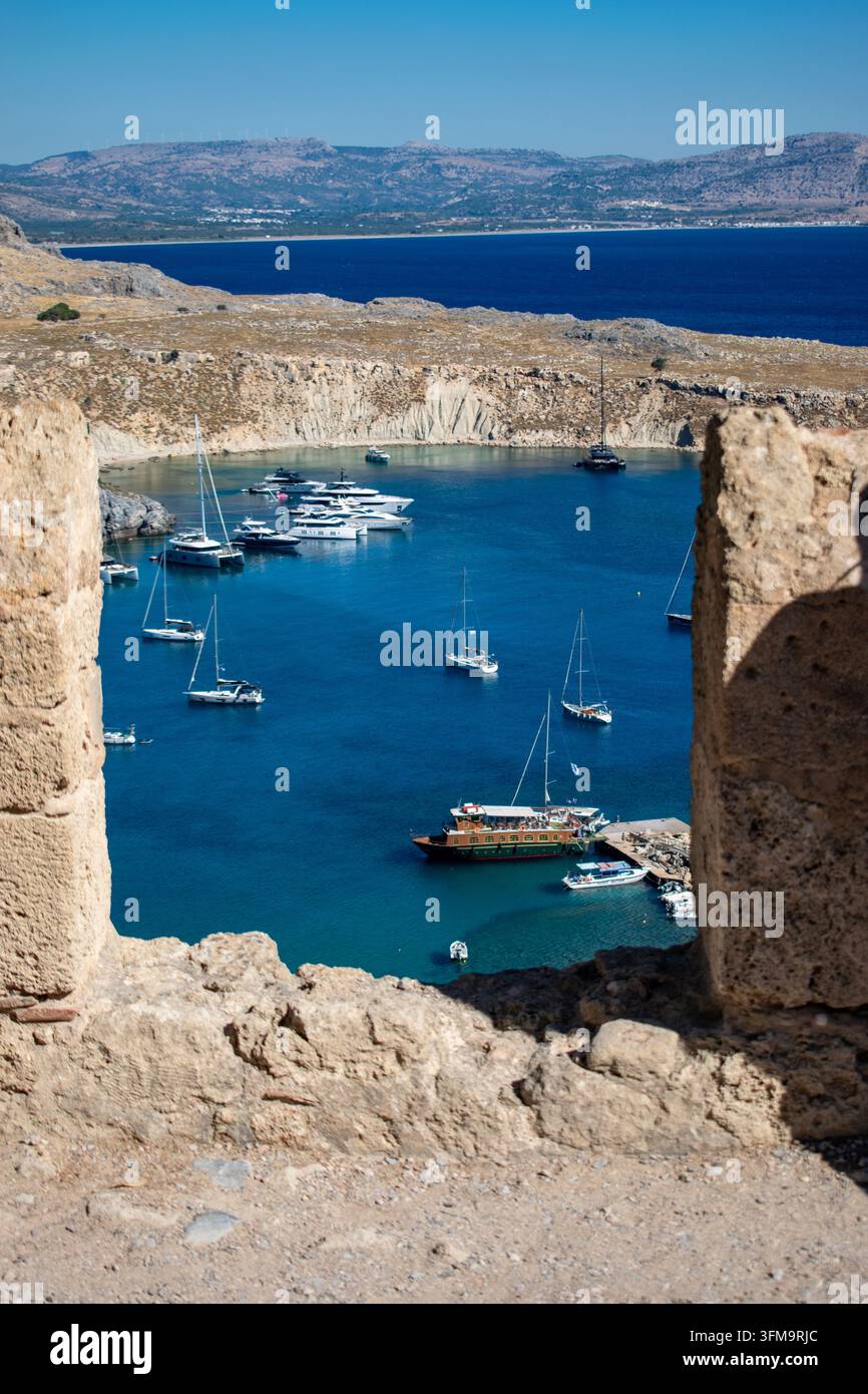 Vue depuis l'Acropole de Lindos sur la baie de Saint-Paul avec des yachts et des bateaux ancrés dans une eau turquoise, Rhodes, Grèce. Banque D'Images
