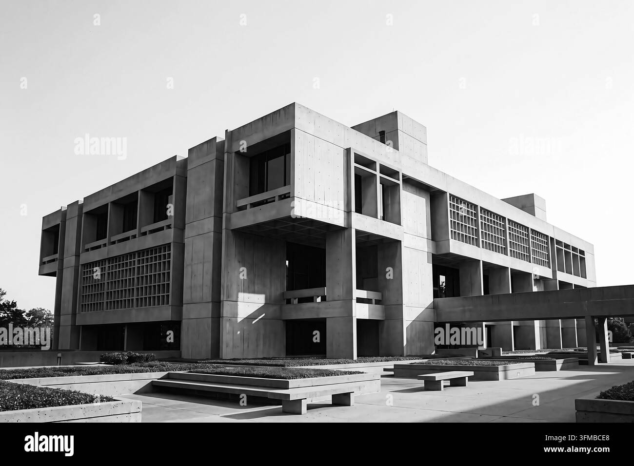 Vue extérieure d'un bâtiment brutaliste moderne en béton présentant des structures géométriques massives, des fenêtres angulaires aiguës, une façade en béton brut exposé et bo Banque D'Images
