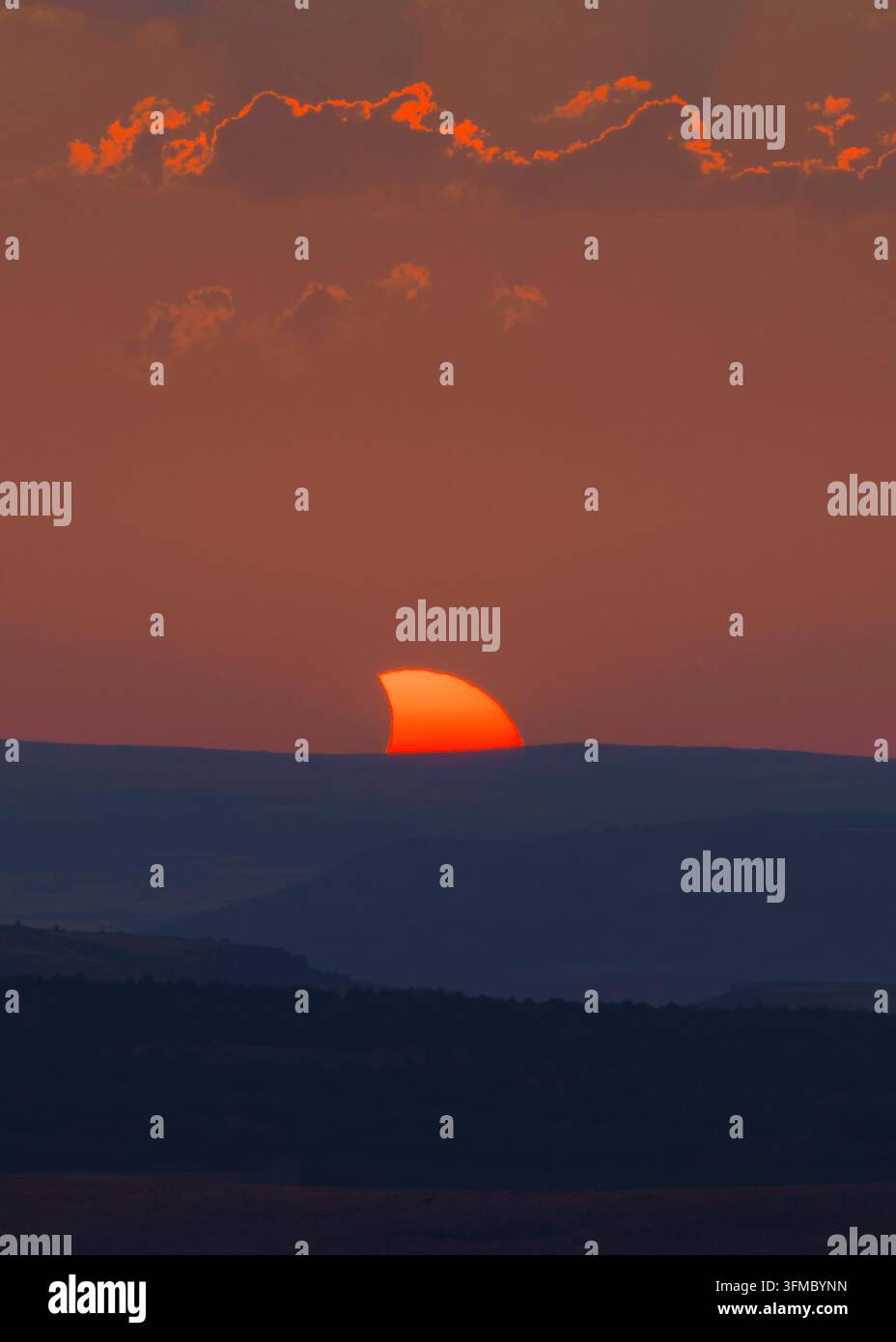 Admirez la beauté du soleil partiellement masqué lors d'une éclipse solaire époustouflante en Espagne, projetant une lueur envoûtante au coucher du soleil Banque D'Images