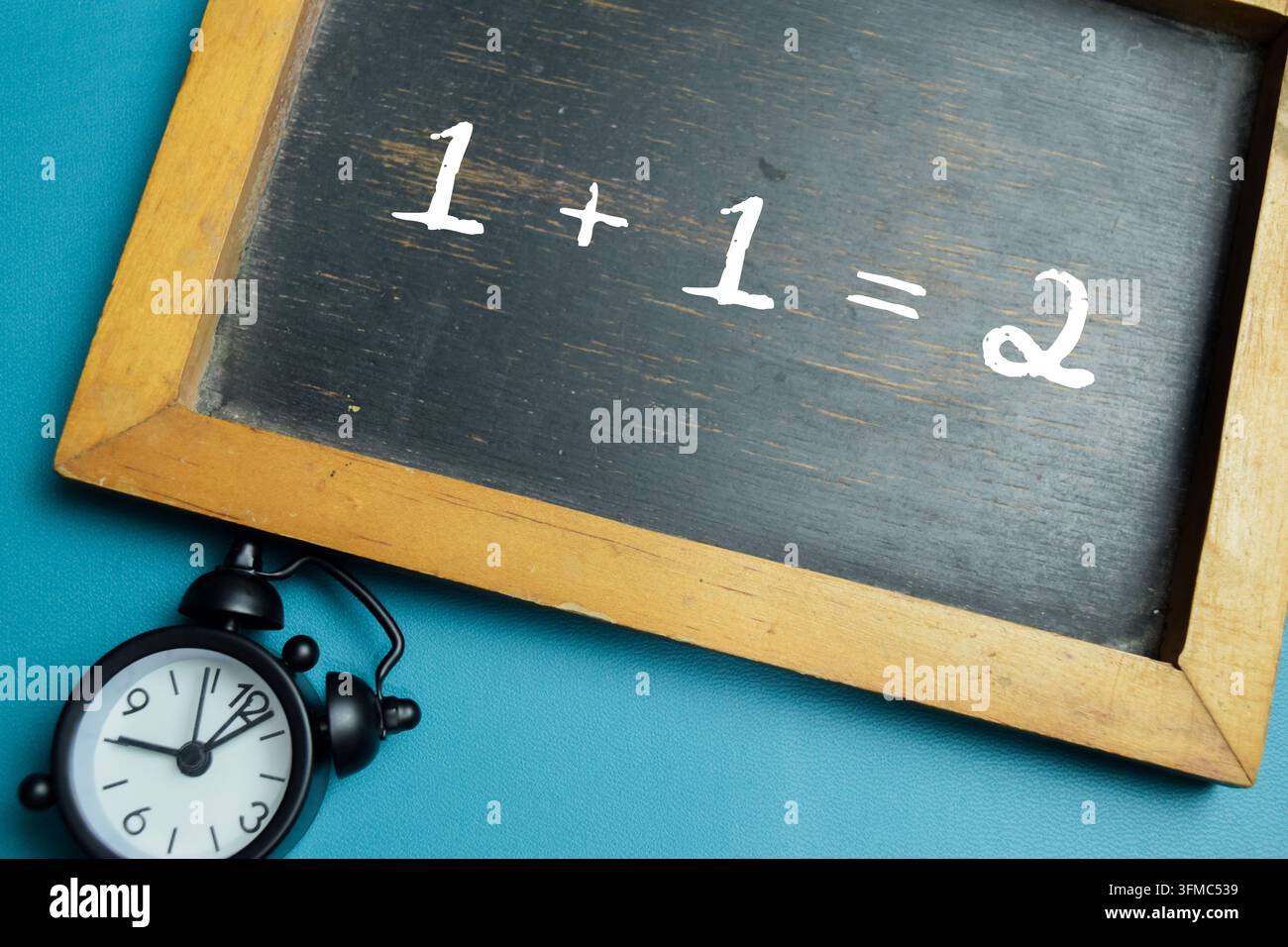 Tableau noir avec la phrase 1 + 1 = 2 équation d'addition sur un bureau en bois. Pour l'arithmétique de base et l'éducation scolaire Banque D'Images