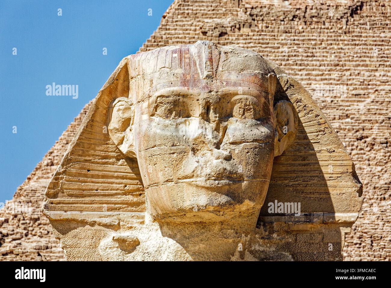 GIZEH, ÉGYPTE – 9 MARS 2026 : Gros plan du visage de la Grande Sphinx de Gizeh avec des traces de pigment rouge sur le couvre-chef nemes ; la maçonnerie du Py Banque D'Images