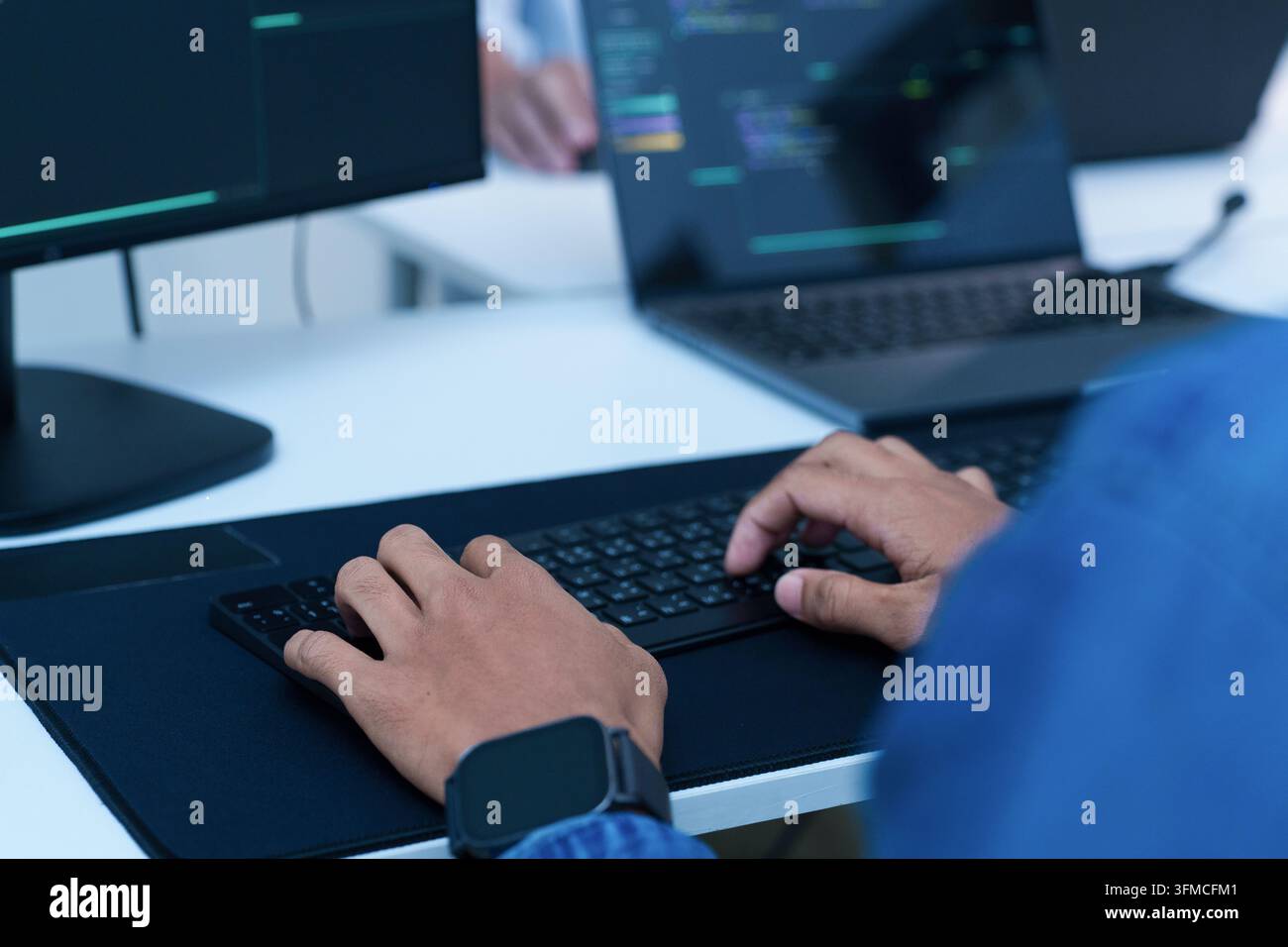 Programmeur écrivant du code sur un ordinateur portable Banque D'Images