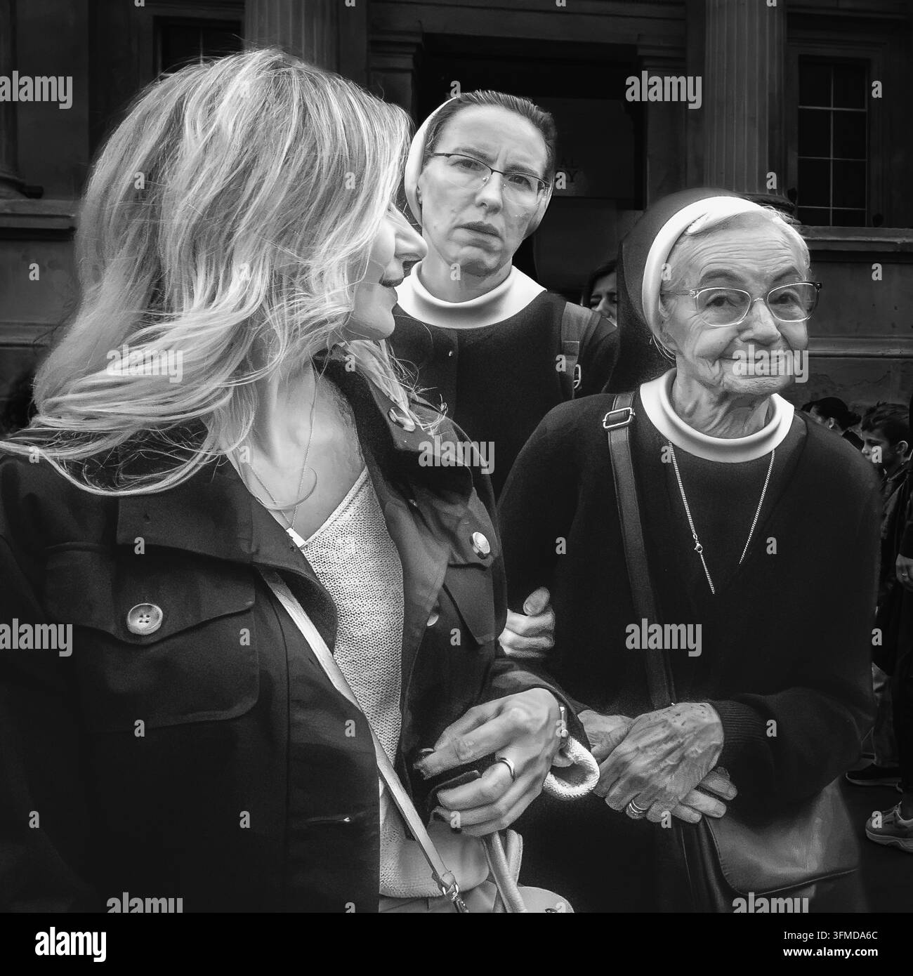 Image en noir et blanc de deux sœurs catholiques marchant dans une rue de Londres, capturée dans un style documentaire authentique. Banque D'Images