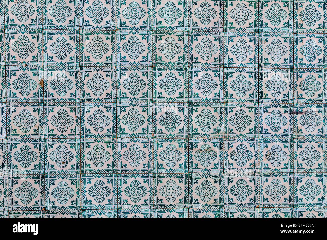 Arrière-plan symétrique en format plein avec des carreaux de céramique portugais azulejos bleus et verts traditionnels présentant des motifs géométriques et floraux complexes Banque D'Images