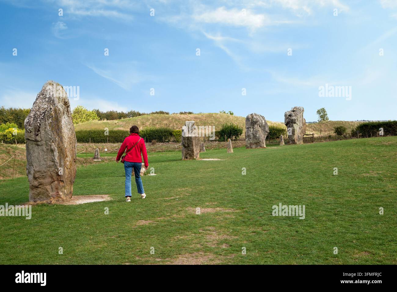 Visiteur marchant à travers les mégalithes massifs du cercle de pierres d'Avebury à Wiltshire, en Angleterre Banque D'Images
