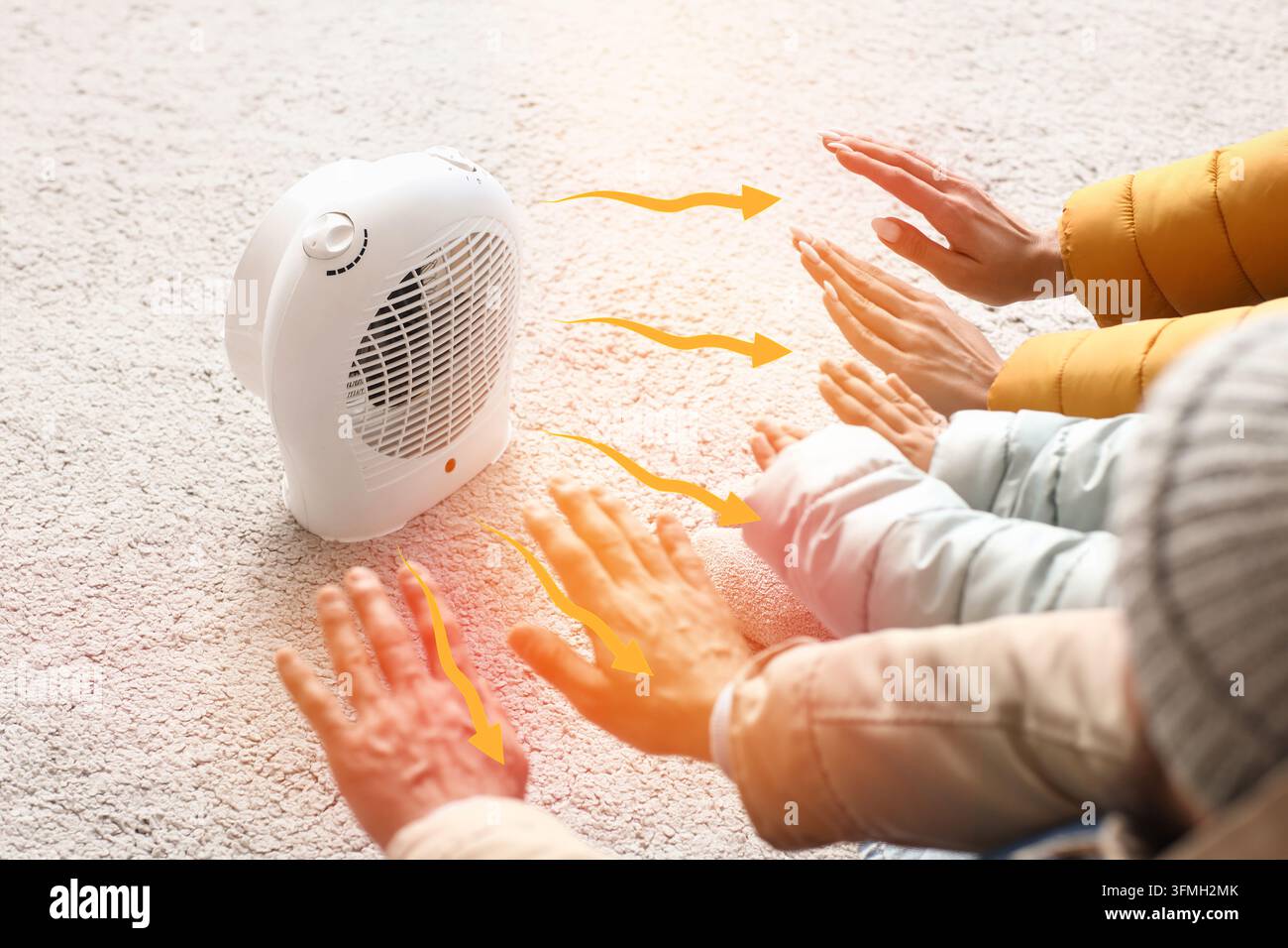 Pauvreté énergétique et chauffage hivernal, des personnes réchauffant leurs mains sur un radiateur électrique à ventilateur pour lutter contre les températures intérieures froides et la hausse des coûts des services publics Banque D'Images