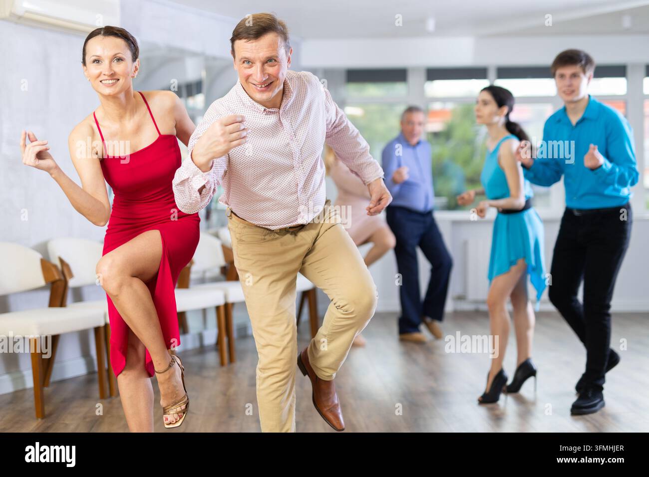 Couple dynamique s'engageant dans la danse latino en studio de danse. Danse de salle de bal par paires en studio Banque D'Images