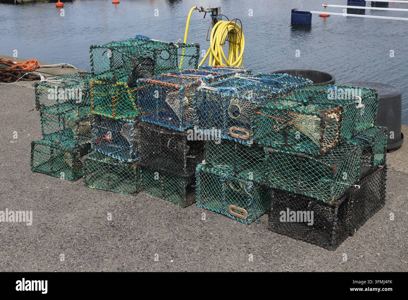 Pile de casiers de pêche traditionnels utilisés pour attraper des homards et des crabes dans un port de pêche sur la côte ouest suédoise. Corde colorée, filets de pêche et ma Banque D'Images