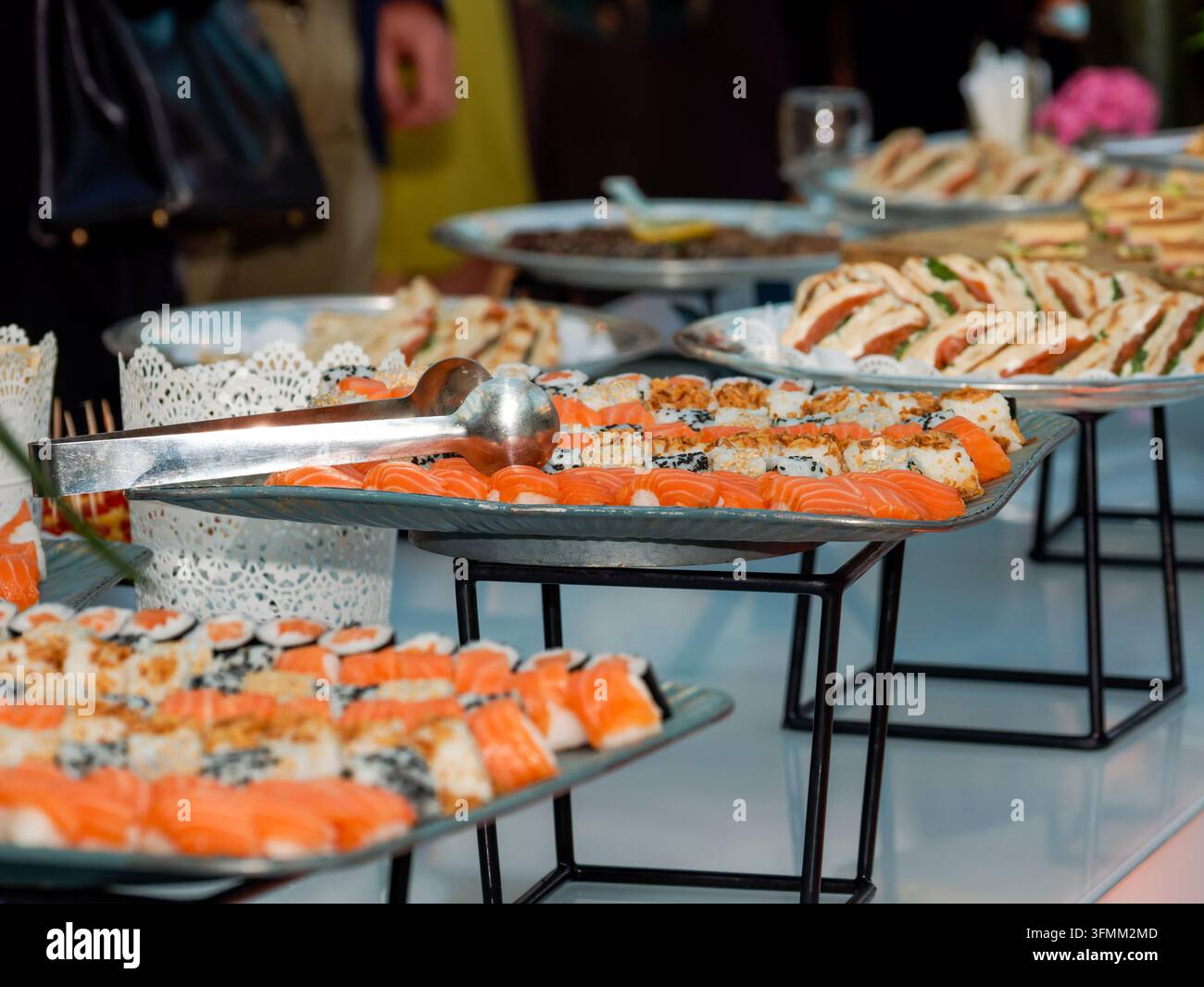 Une table de buffet avec des sushis et des sandwichs variés lors d'un événement traité à l'intérieur. Banque D'Images
