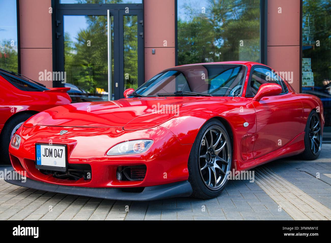 Vilnius, Lituanie - 2026-06-06 - Légende de l'âge d'or de JDM : une voiture de sport Mazda RX-7 rouge avec moteur rotatif et pare-chocs personnalisé Banque D'Images