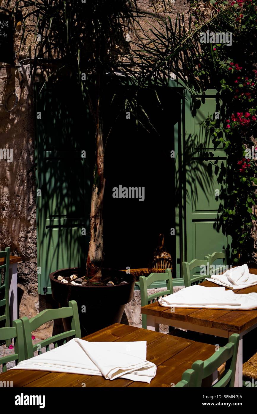 Terrasse de restaurant extérieure confortable avec des chaises vertes Banque D'Images