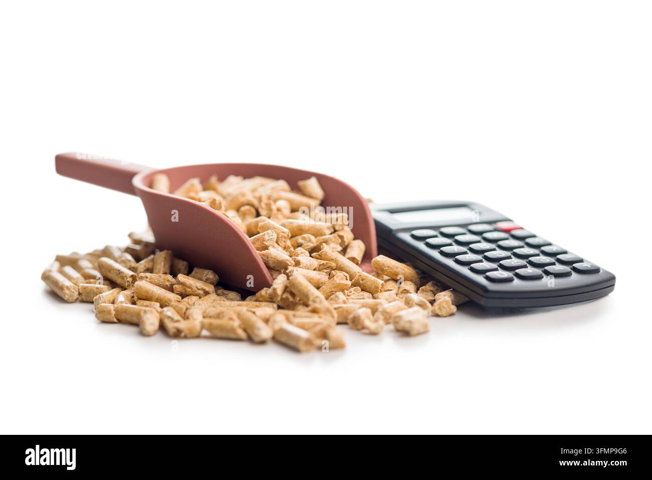 Cuchée de granulés de bois à côté d'une calculatrice suggérant des calculs des coûts de chauffage, le budget énergétique et l'économie de combustible biomasse pour le chauffage domestique, durable Banque D'Images