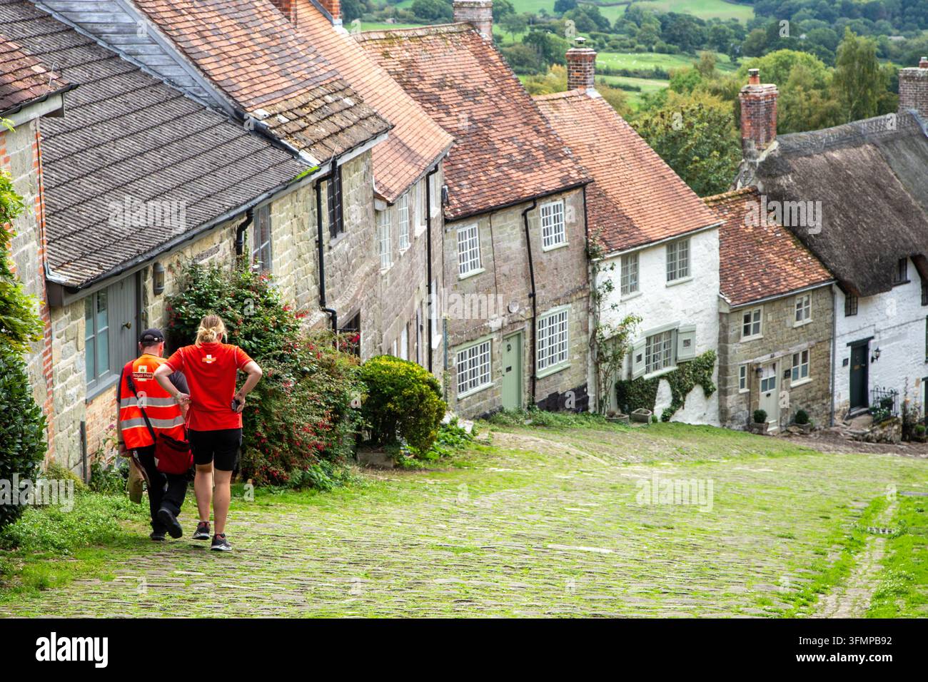 Royal Mail livre à une rangée de cottages de campagne sur Gold Hill dans la ville de Shaftesbury dans le Dorset, rendue célèbre par la publicité télévisée pour le pain Hovis Banque D'Images