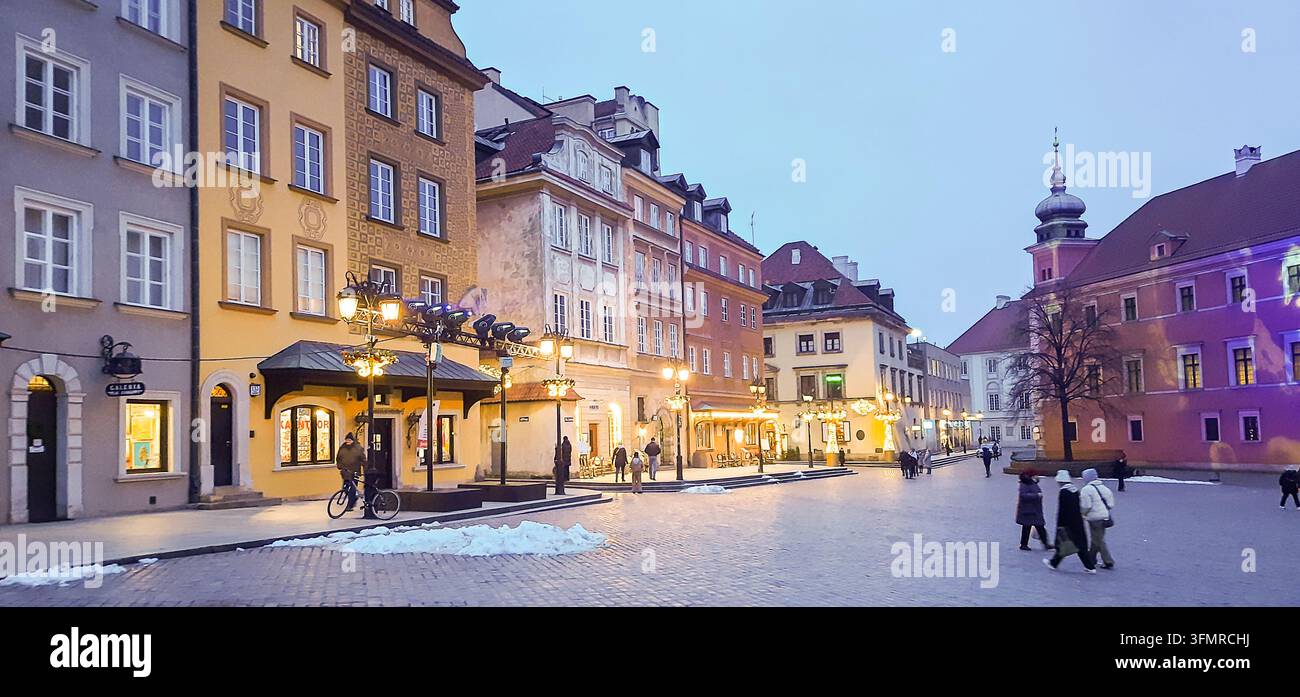 Place européenne historique avec des maisons de ville colorées et un sapin de Noël illuminé au crépuscule - Varsovie, Pologne - 26 janvier 2023 Banque D'Images