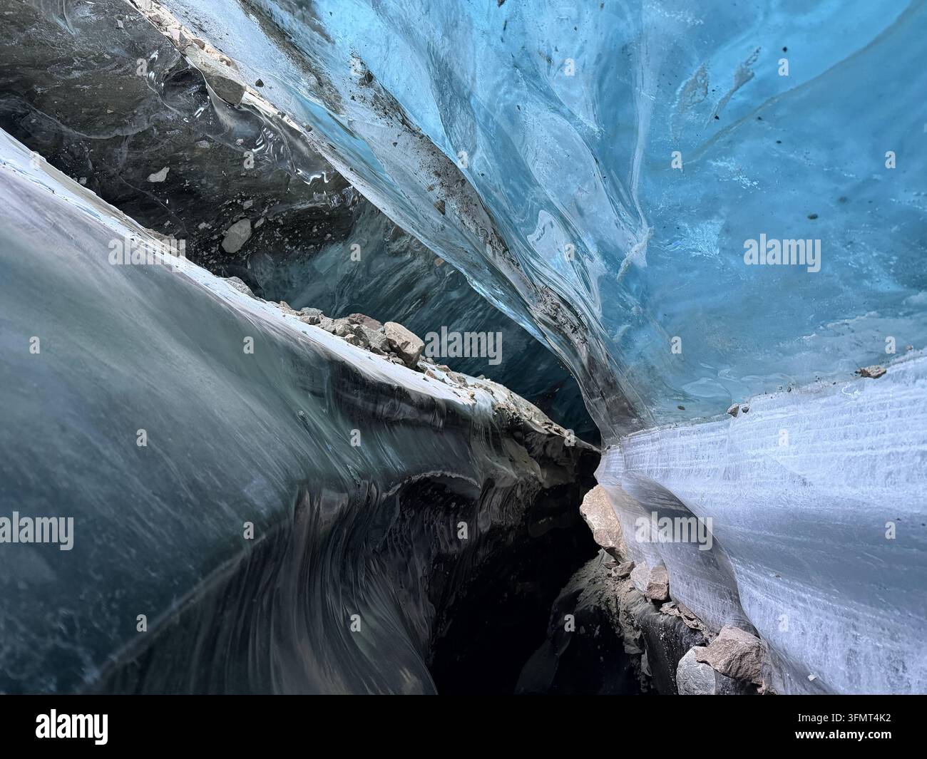 La glace glaciaire bleue et noire entoure un passage étroit au sein du glacier Bogdanovich dans l'Ile Alatau près d'Almaty, au Kazakhstan. - Image de stock capturée avec un smartphone