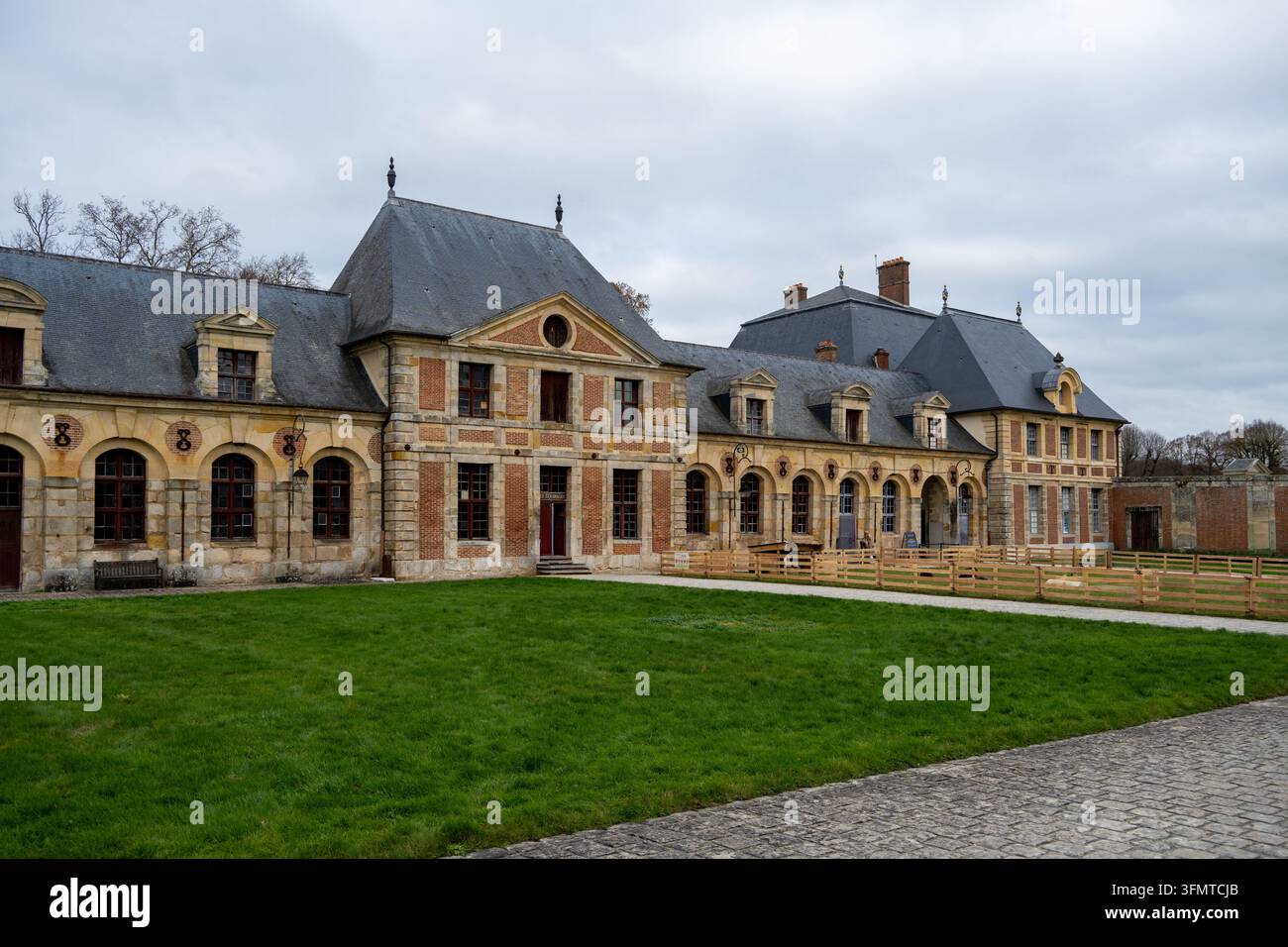 Longs bâtiments de grange en brique et en pierre avec des fenêtres en arc et des toits en ardoise au Château de Vaux-le-Vicomte à Maincy, France. Banque D'Images
