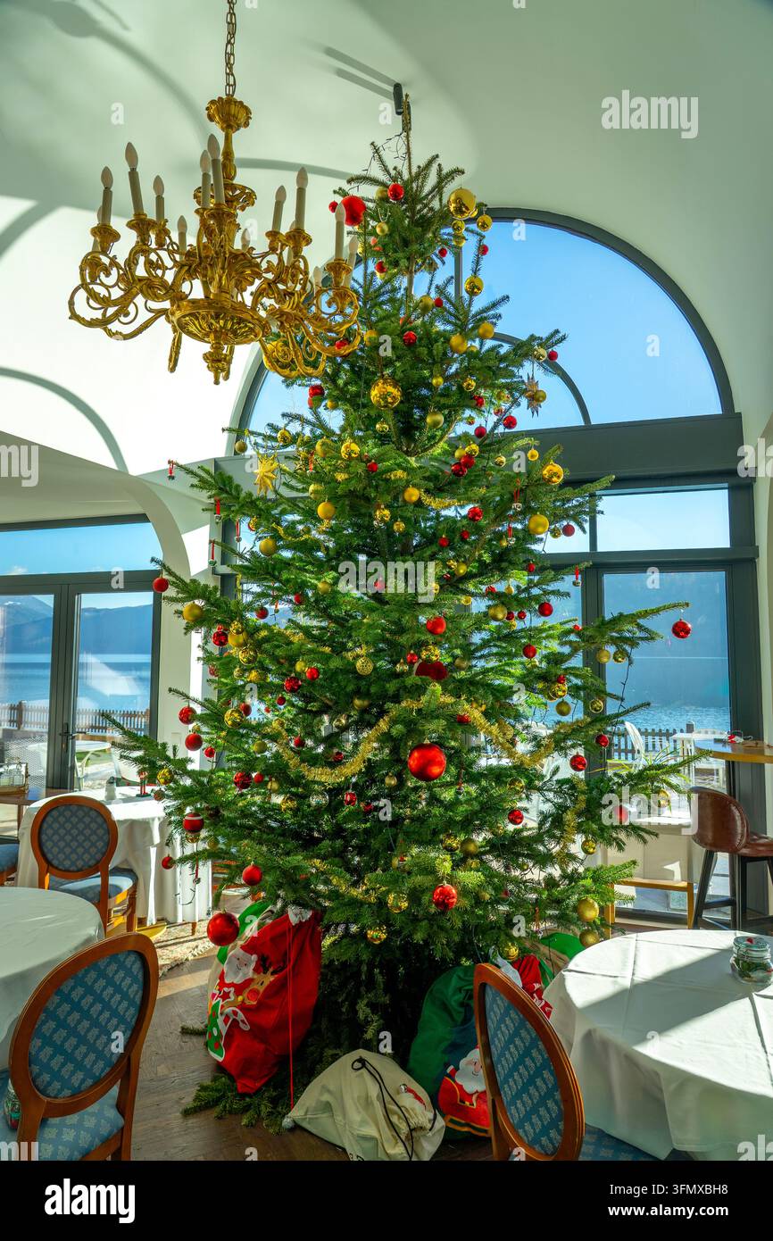 Grand sapin de Noël décoré dans un restaurant élégant au bord du lac Banque D'Images