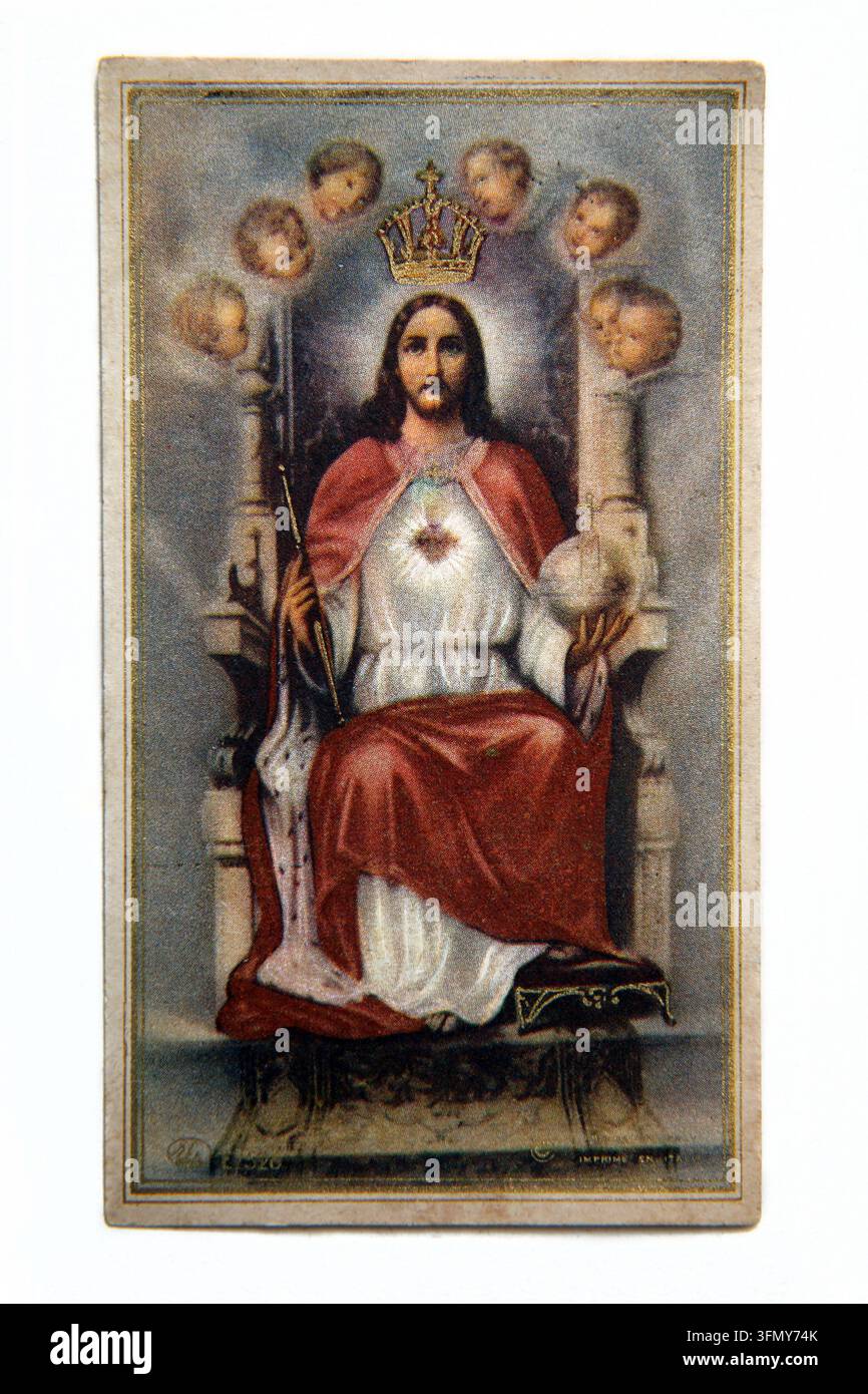 Une carte de prière dévotionnelle vintage représentant Jésus-Christ en tant que Roi avec le Cœur Sacré, entouré de la tête d’un chérubin ailé et de séraphins Banque D'Images