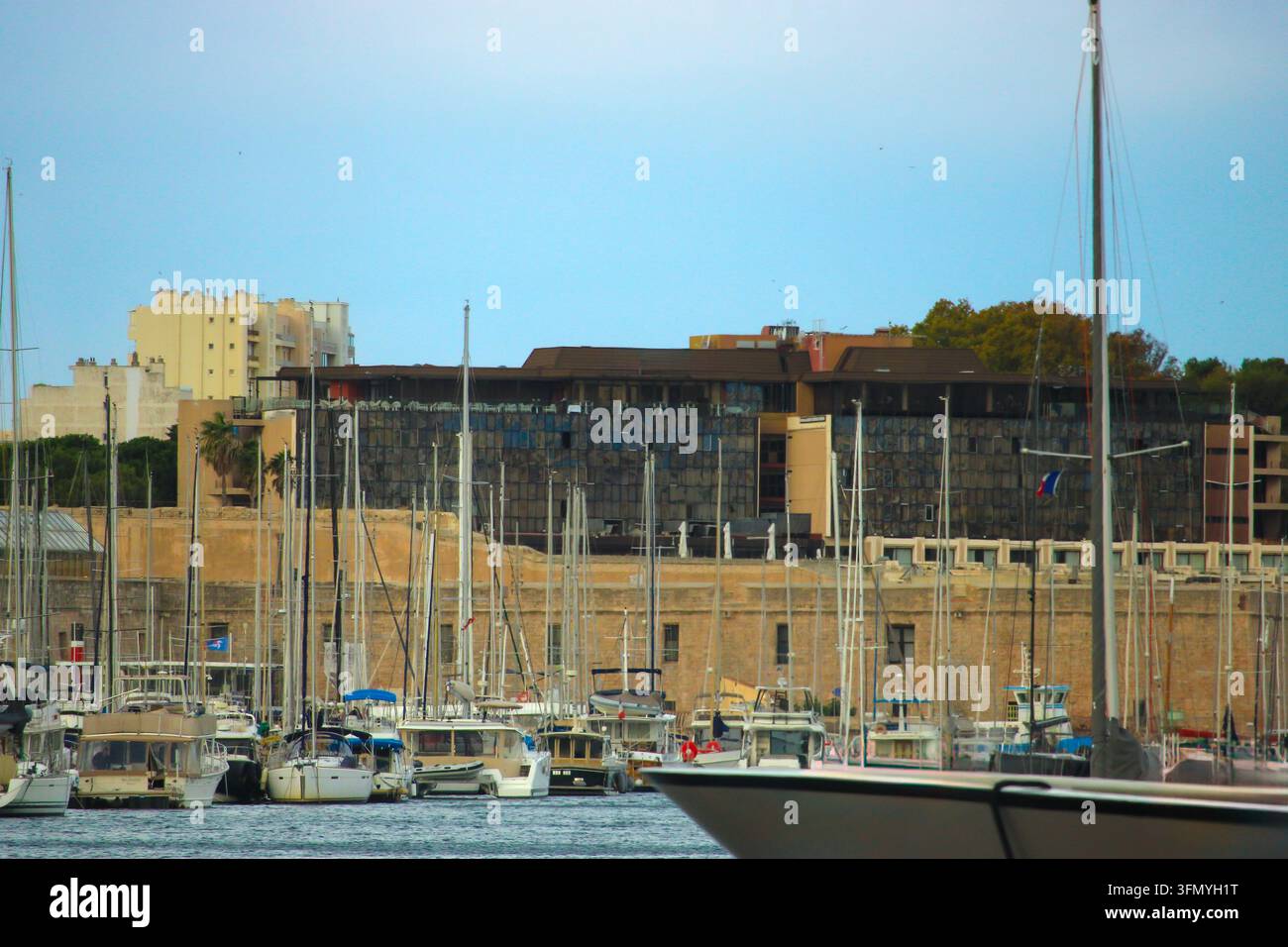 Bateaux à voile et yachts amarrés dans une marina avec des bâtiments riverains en arrière-plan Banque D'Images