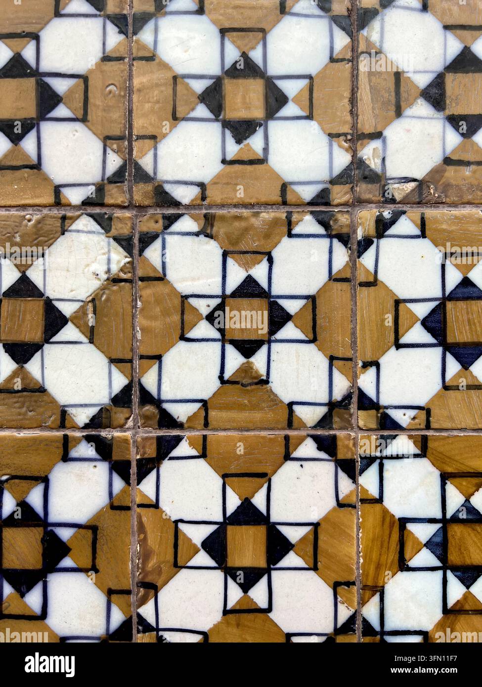 Anciens carreaux azulejo portugais avec un motif géométrique ocre, blanc et bleu marine sur un mur au Portugal - Image de stock capturée avec un smartphone