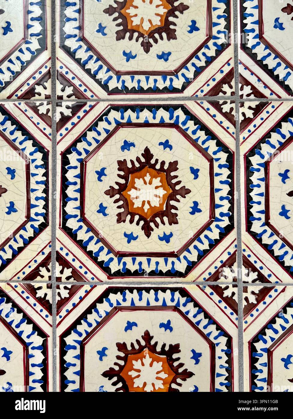Carreaux de céramique azulejo peints à la main au Portugal avec un motif octogonal répétitif en bleu, marron et orange - Image de stock capturée avec un smartphone