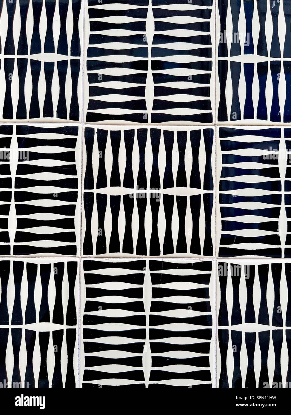 Carreaux de céramique azulejo noirs et blancs avec un motif géométrique de rayures tissées sur un mur au Portugal. - Image de stock capturée avec un smartphone