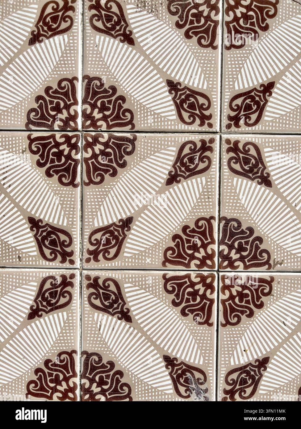 Carreaux de céramique azulejo portugais avec un motif ornemental en rouleau brun et des rayures blanches, Portugal - Image de stock capturée avec un smartphone